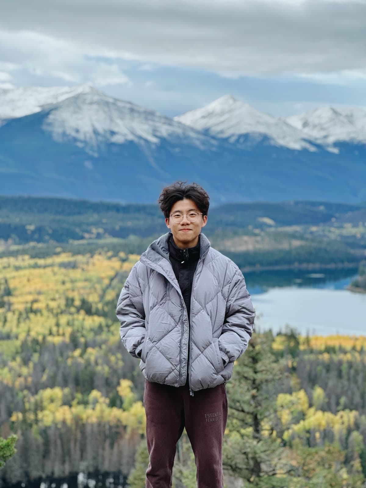 Jay standing on a hillside in front of mountains
